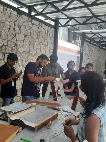 An overhead view of the students deeply engaged in building their furniture projects.