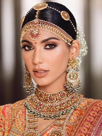 A close-up of the South Indian bridal look, focusing on the sharp, defined eyes and the intricate headpiece. The skin is kept flawless and radiant.