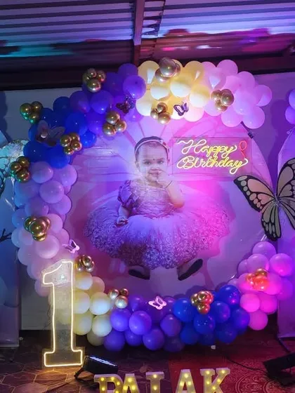 A beautiful butterfly-themed first birthday with a large photo backdrop and a blue and yellow balloon arch.