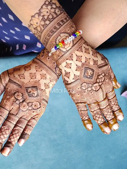 A heavy Indian design on the back of the hands, featuring elephant motifs in a diamond frame. The surrounding patterns are dense and intricate, creating a rich, traditional look.