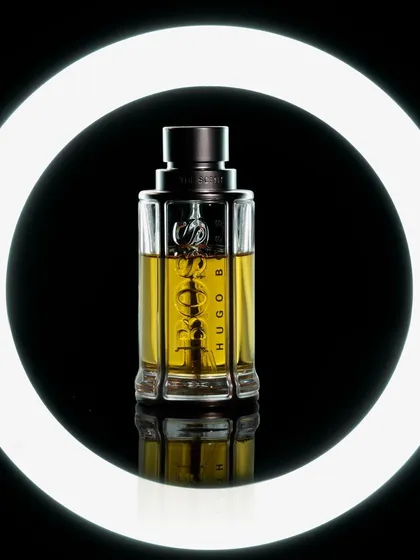 For this perfume shot, I used a ring light to create a bold, graphic frame around the bottle. This technique isolates the product against a pure black background, emphasizing its clean lines and the color of the fragrance. It is ideal for modern digital marketing and social media visuals.