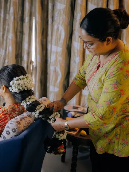 Placing a gajra on a traditional bridal hairstyle. Learning to work with fresh flowers and hair accessories is a key part of my hairstyling module.