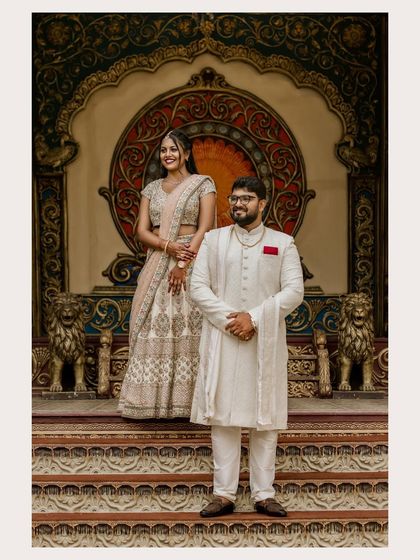 A formal portrait of the couple standing on an ornate stage, looking elegant and happy.