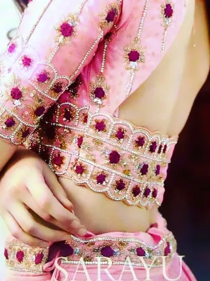 This photo shows how my custom blouses fit. This pink blouse has intricate floral embroidery with beadwork on the sleeves and waist, designed to look elegant and feel comfortable. The finishing is very neat.
