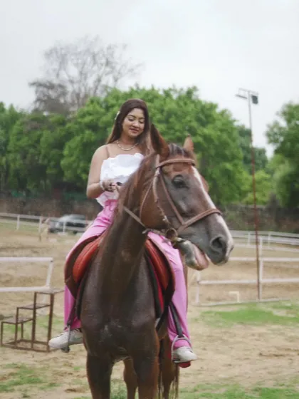 A rider sits confidently on her horse in the practice arena, showcasing the relaxed and trusting relationship developed through time and training.