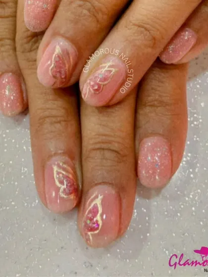 An elegant design featuring shimmery pink nails with accent nails adorned with 3D golden butterfly outlines.
