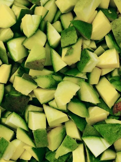 The process of chopping raw mangoes for my pickles. I ensure they are the perfect size for a good bite.