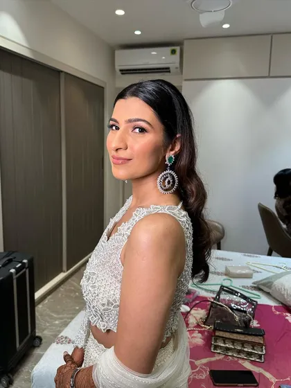 The client looking radiant for her Roka ceremony. The soft waves are styled away from the face to highlight her features and jewelry.