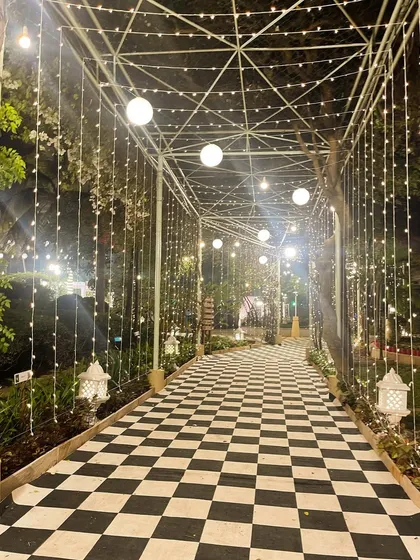 A modern and graphic entrance walkway with a checkered floor and a tunnel of lights. This design is perfect for a contemporary, high-fashion wedding reception.