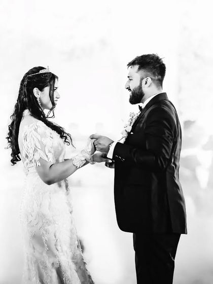 A quiet moment amidst the celebration. This black and white photo shows the couple holding hands during their first dance, surrounded by soft fog.