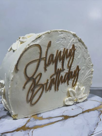 This was my first time making a top-forward cake, and it was a fun challenge. The design features an elegant white-on-white textured pattern and a gold "Happy Birthday" topper.
