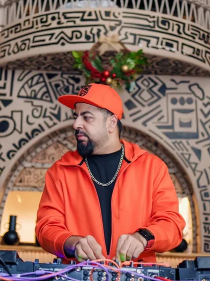 On the decks at Bastian during the Gypsy Groove event. The orange jacket and festive decor set the mood.