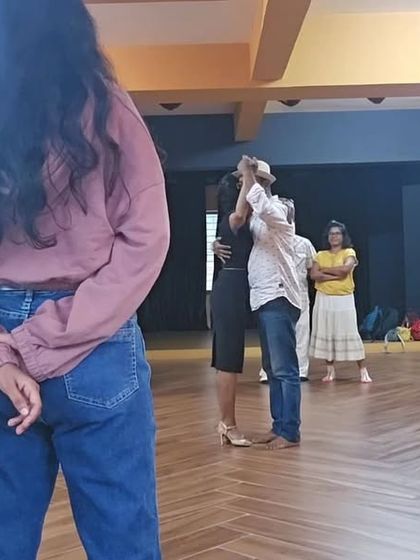 Here, I'm demonstrating a basic hold with a student while others observe. This hands-on approach helps clarify the subtle details of the Tango embrace.