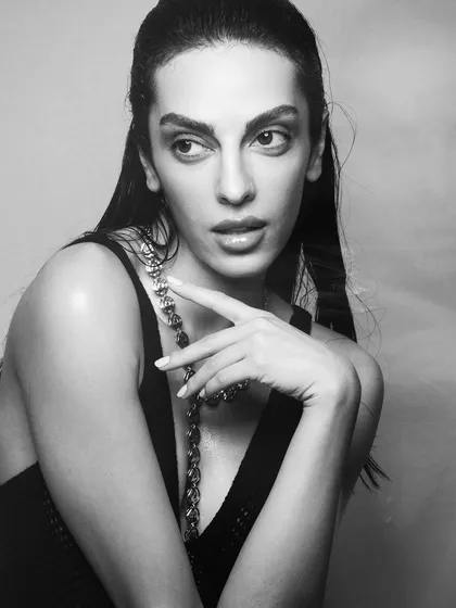 A classic black and white portrait that highlights the structure of the face and the clean makeup application.