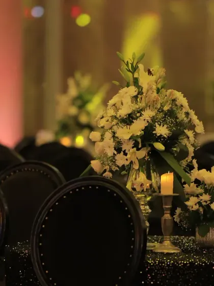For guest seating, we used tables with black sequined cloths and classic black chairs. The tables were adorned with simple white floral centerpieces and candles, maintaining the chic black and silver theme.