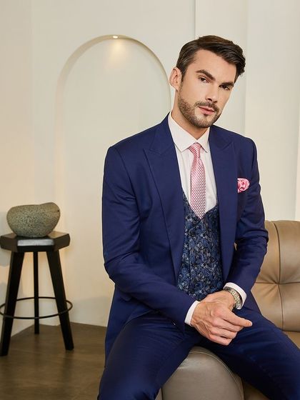 Seated, the three-piece suit remains impeccable. This demonstrates the importance of a bespoke fit for maintaining a polished look in any professional setting.