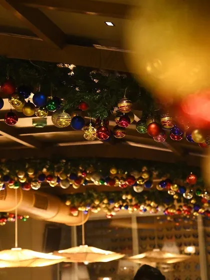 A view of the Christmas decor from a diner's perspective, with the colorful ornaments creating a beautiful blurred effect in the foreground.