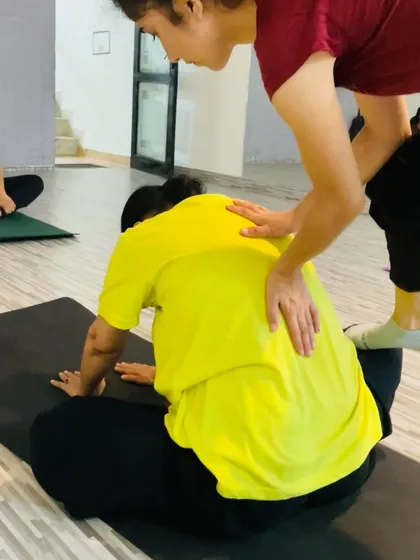 I believe in providing personalized attention to help you progress. Here, I'm assisting a student to safely deepen her posture, ensuring she gets the most out of every stretch without risking injury.