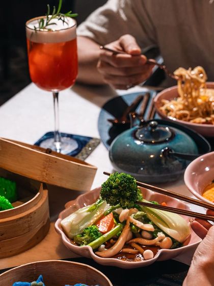 A shared meal during our South East Asia brunch at Terra. The table is filled with a variety of dishes, from noodles and steamed vegetables to delicate dim sum, showcasing the communal and flavorful nature of Asian dining.