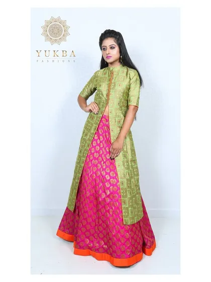 A full view of the green and pink layered gown, showcasing the vibrant color combination and brocade fabrics.