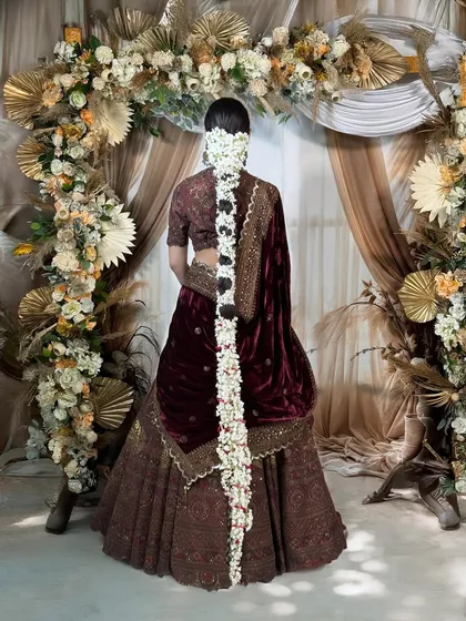 The back view highlights a breathtaking floral braid, cascading down the bride's back. This traditional jasmine 'gajra' hairstyle adds a fragrant and beautiful touch to the overall bridal look.