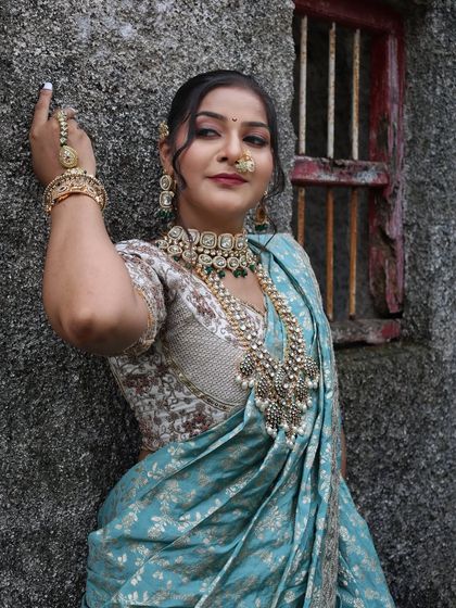 A confident pose against a rustic wall, showing the versatility of the blue Nauvari.