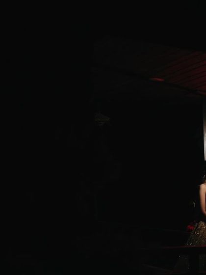 A solitary, dramatic portrait of Ipsa under a single red light. This artistic shot uses color and shadow to create a powerful, moody, and cinematic image.