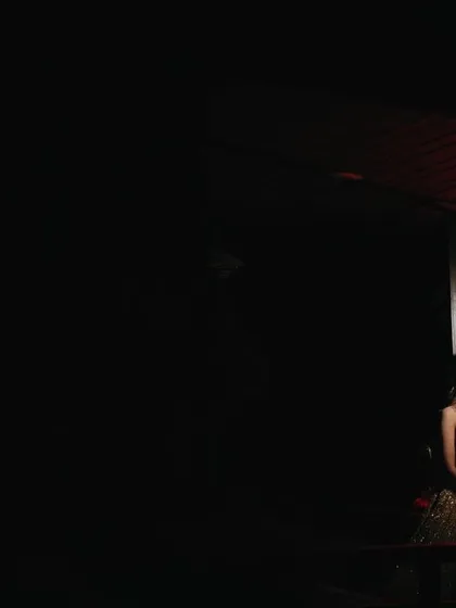 A solitary bridal portrait under a dramatic red light. The minimalist composition and use of color create a powerful, moody, and unforgettable image.