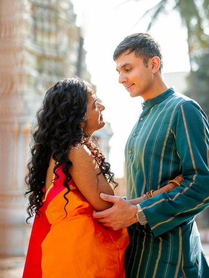 A sweet pre-wedding moment captured near a temple. The couple's interaction is natural and full of affection.