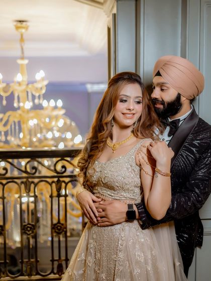 An elegant portrait of Simran and Sanjit. The opulent chandelier and grand doorway in the background add a touch of luxury to this classic, romantic embrace.