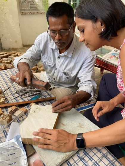 A participant in our woodblock carving workshop gets one-on-one guidance from a master artisan. We aim to pass on this rare skill and inspire a new generation of carvers.