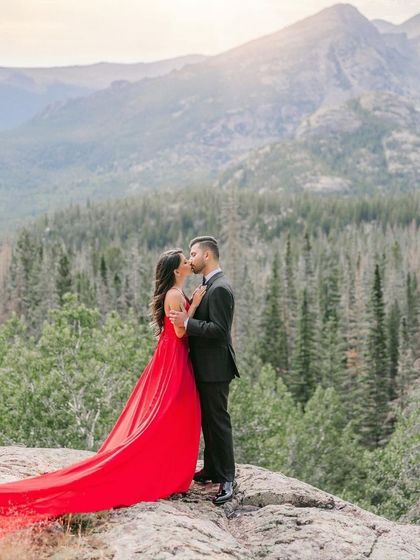 A close-up of the couple during their mountain pre-wedding shoot. The bride's red gown with its long train creates a beautiful, romantic image.