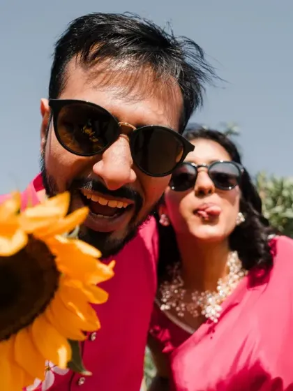 A fun, wide-angle selfie with a sunflower. This shot is full of energy and personality, capturing the vibrant and playful spirit of the Haldi celebration.