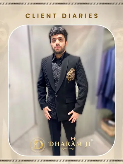 A client trying on his new black suit with an asymmetrical design and a gold embroidered motif. The fit is already looking great.