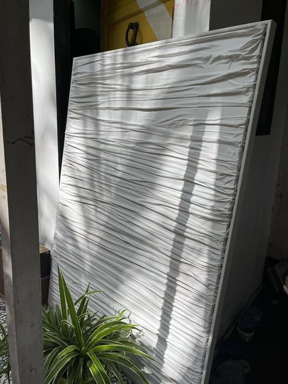 My white fabric art piece, seen in my studio catching the light. The sculptural drapes and folds create an ever-changing pattern of light and shadow.