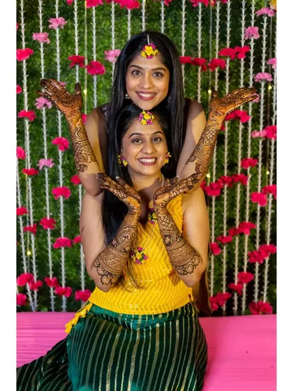 Fun with the bridesmaids. A playful pose showing off everyone's beautiful mehendi designs.