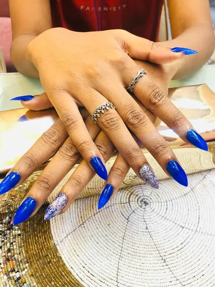 A bold royal blue set with silver glitter accent nails for a high-contrast, striking look.