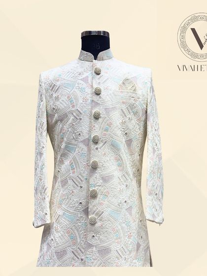 The front view of our signature ivory and pastel sherwani. Notice how the detailed buttons and fine embroidery come together to create a balanced and majestic look for your wedding day.