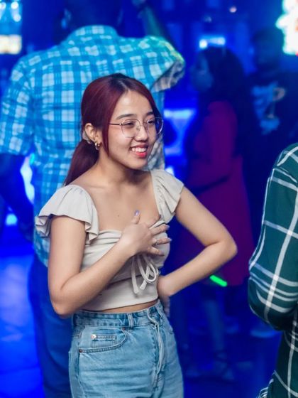 A guest smiling and chatting with friends on the dance floor.
