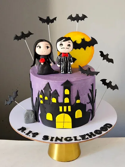 For a couple with a great sense of humor, I designed this "R.I.P. Singlehood" cake for their cocktail party. Inspired by a classic horror theme, it features a haunted castle silhouette against a full moon and edible figurines of the couple as gothic characters. This shows my ability to create fun, unconventional cakes for any occasion.