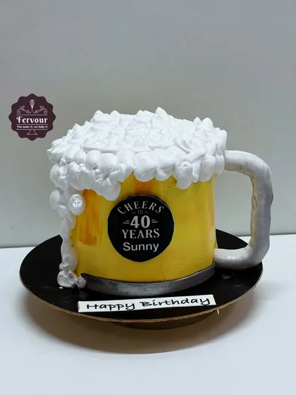 A fun beer mug cake to celebrate a 40th birthday. This 3D cake is shaped like a mug of beer, complete with frothy whipped cream foam on top.