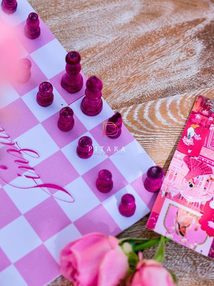 The custom pink chessboard surrounded by roses, a perfect example of how we weave a theme into every single detail.