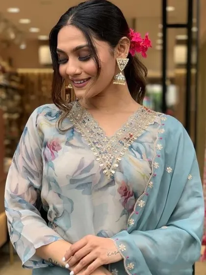 A grey premium organza kurta with a soft floral print. The delicate thread embroidery on the neckline adds a touch of elegance.