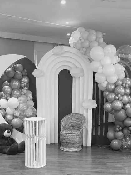 A complete baby shower stage setup in black and white, showcasing a large moon prop, an arched backdrop, and cascading balloon garlands. This demonstrates the structure and scale of my designs.