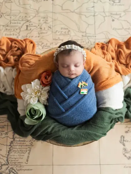 Another patriotic setup, with the newborn resting on a map of India, wrapped in the tricolor. A beautiful way to mark a baby's August birth.