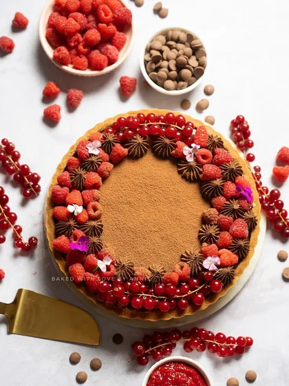 A beautiful Raspberry and Milk Chocolate Tart. The crumbly biscuit base, house-made raspberry compote, and luscious Belgian milk chocolate filling make for a truly decadent dessert.