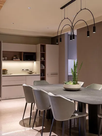 A minimalist kitchenette and dining area where functionality meets sophistication. The sleek, handleless cabinets and modern dining set create a clean and uncluttered look.