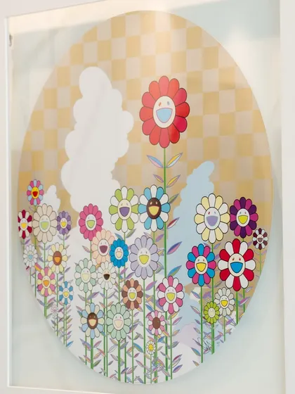 An angled shot of the Takashi Murakami piece. His signature smiling flowers are on full display, blending cheerful aesthetics with a deeper subtext.