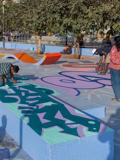 A shot of the collaborative spirit, with different artists working side-by-side on their sections of the skatepark mural.