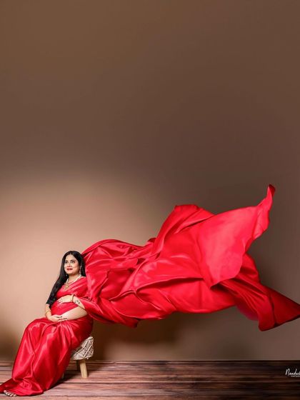 Another angle of the flowing red saree, creating a powerful and artistic silhouette. This shows the creative possibilities within a studio shoot.